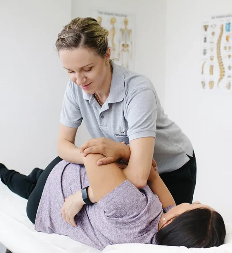 Ana, women's health physiotherapist, giving a hands-on hip assessment to a patient in her clinic