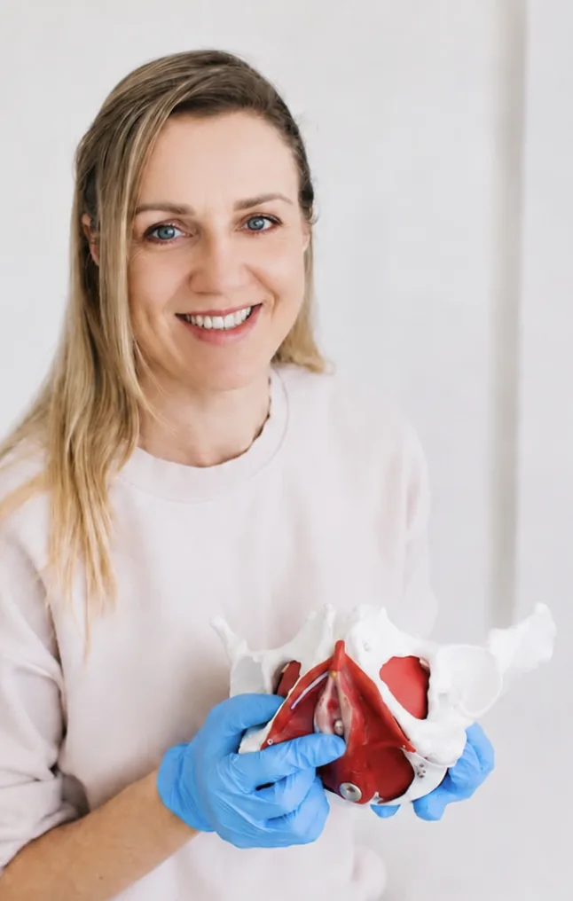 Ana holding a pelvic anatomy model